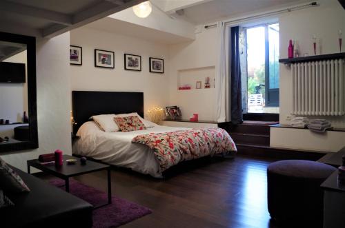 a bedroom with a bed and a large window at Chambres d'hôtes Home Sweet Home in Ciré-dʼAunis