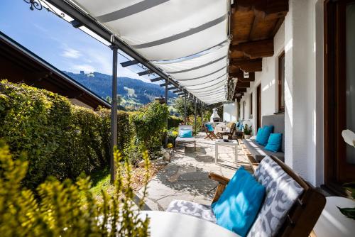 a patio with chairs and tables on a building at Sportpension Bergblick in Wagrain