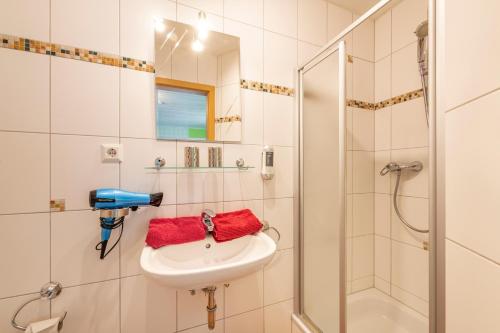 La salle de bains est pourvue d'un lavabo et d'une douche. dans l'établissement Pension Gisela, à Gößweinstein