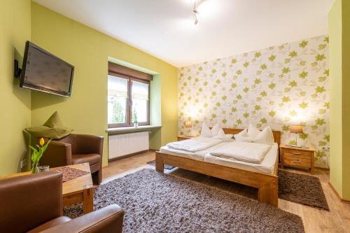 a bedroom with a bed and a tv on the wall at Pension Gisela in Gößweinstein