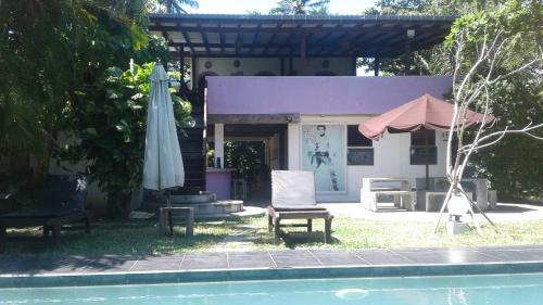 an umbrella and a chair next to a pool at Turtle Eco Beach in Matara