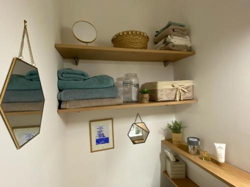 baño con estantes de madera y toallas en la pared en Cocon d'Emeraude Saint-Malo, en Saint-Malo