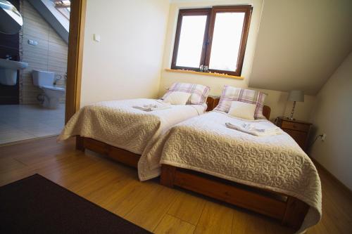 1 dormitorio con 2 camas y ventana en Ośrodek Wypoczynkowo Sportowy Pod Żurawiem, en Lniano