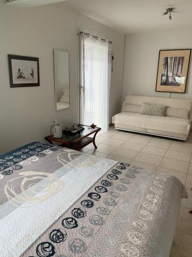 a white room with a bed and a couch at Bed and Breakfast La Petite Thielle in Cressier