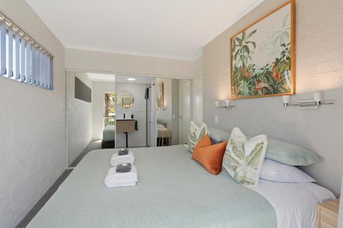 Un dormitorio con una cama grande con una báscula. en The Palms Apartments, en Merimbula