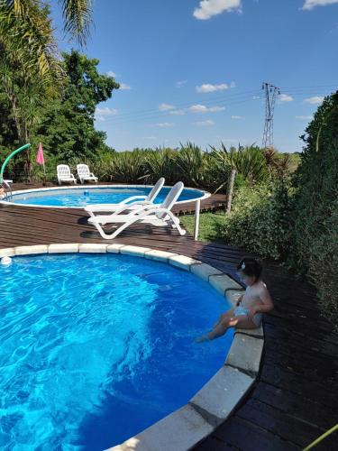 un niño pequeño está sentado en una piscina en Cabañas Tierra Linda, en Concepción del Uruguay