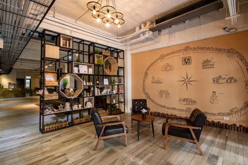 a room with two chairs and a table and a wall at Hotel Brown - Chihkan Branch in Tainan