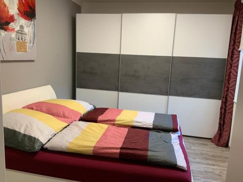 a bed with a colorful comforter in a bedroom at Neurenovierte FeWo Harztor in Nordhausen