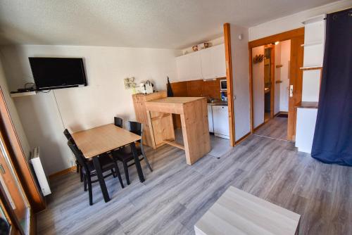 a kitchen and dining room with a table and a dining room at L'Enchalpe, Grand et lumineux studio avec coin montagne 5 personnes, 60m des pistes, PISCINE COUVERTE, WIFI, grand balcon expo EST, DRAPS NON COMPRIS in Saint-Jean-dʼAulps