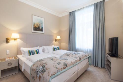 a hotel room with a bed and a television at Hotel an der Oper in Munich