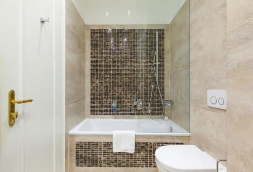 a bathroom with a tub and a toilet and a sink at Hotel an der Oper in Munich