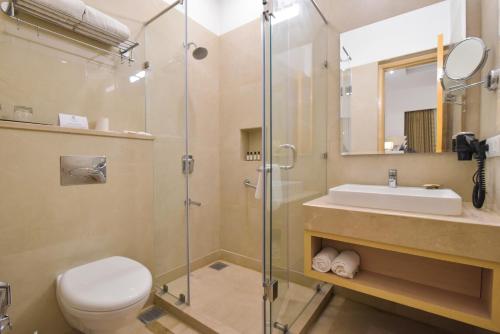 a bathroom with a shower and a toilet and a sink at SureStay Heritage Walk By Best Western in Amritsar