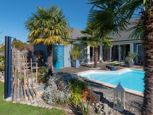 une maison avec une piscine et des palmiers dans l'établissement Escale en Correze, à Sadroc