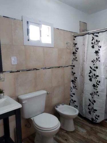 a bathroom with a toilet and a sink at Cabañas Tierra del Sol in Las Rabonas