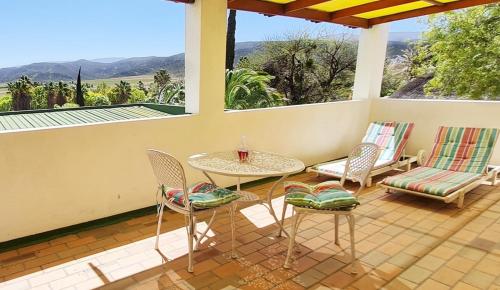 a patio with a table and chairs on a porch at Montagu Little Sanctuary - Hot Spring Access at Special Rate in Montagu