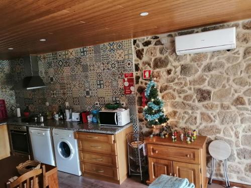 a kitchen with a christmas tree on a stone wall at The Maggie Farm in Aranhas