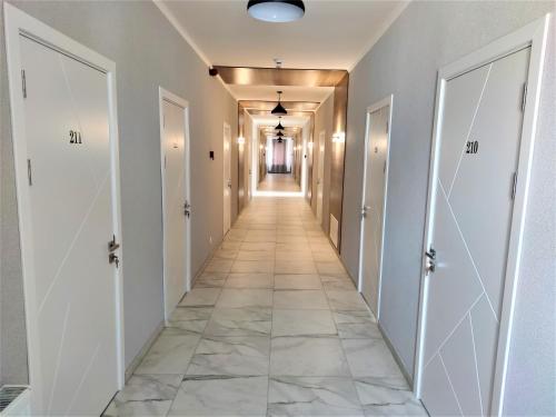 a hallway with white doors and a tile floor at ROCAS Hotel in Orhei