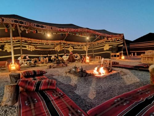 uma grande tenda com uma fogueira no deserto em WADI RUM STAR WARS CAMP em Wadi Rum