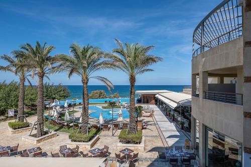 uma vista para um resort com palmeiras e uma piscina em Cretan Dream Resort & Spa em Stalos