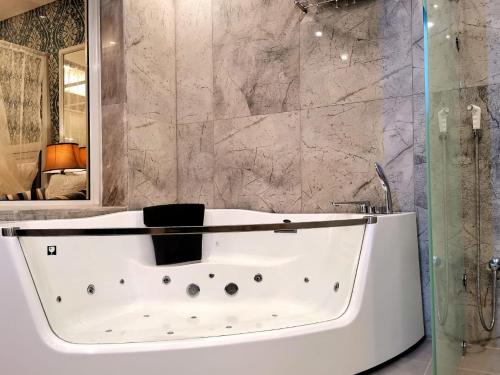 W łazience znajduje się biała wanna i prysznic. w obiekcie Azard Hotel w Medynie