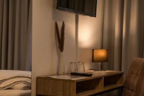 a bed room with a table with a lamp on it at Altstadt Hotel Self Check-In in Würzburg