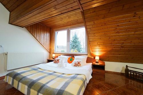 ein Schlafzimmer mit einem großen Bett und einer Holzdecke in der Unterkunft Apartamenty EverySky Kowary - Dom z 5 lub 7 sypialni in Kowary