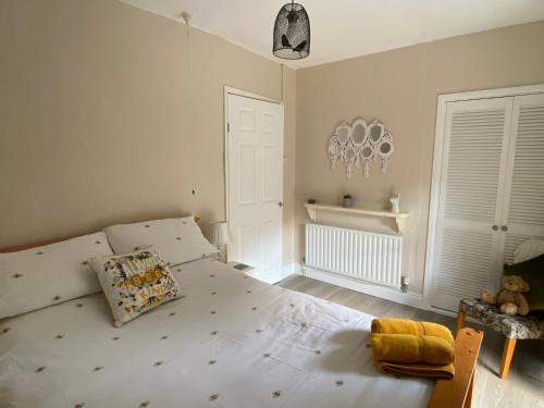 - une chambre avec un grand lit blanc dans l'établissement Ty-Nance Cottage, à Caerphilly