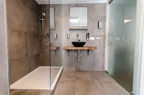 a bathroom with a glass shower with a sink at Altstadt Hotel in Würzburg