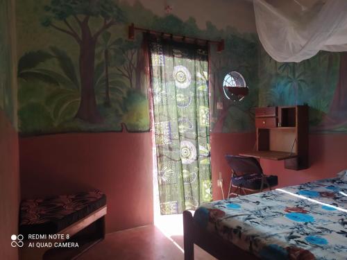sypialnia z łóżkiem i oknem w obiekcie Chez Yaya - Chambre Brousse w mieście Oussouye