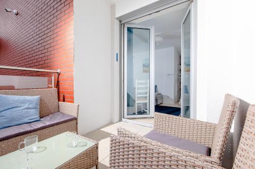 balkon ze stołem i krzesłami oraz oknem w obiekcie Resort Apartamenty Klifowa Rewal 71 w Rewalu