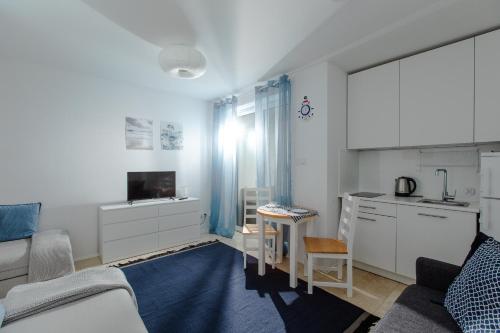 kuchnia i salon z kanapą i stołem w obiekcie Resort Apartamenty Klifowa Rewal 71 w Rewalu