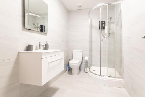 a white bathroom with a shower and a toilet at BEST PRICE - Superb Southampton City Apartments, Single Beds or King Size & Sofabed - AMAZING location close to MAYFLOWER THEATRE FREE PARKING in Southampton