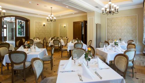 a dining room with white tables and chairs at Polanka Conference Center in Krosno