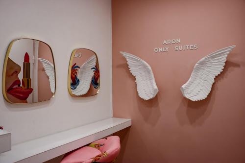 a wall with two mirrors and angel wings on it at Aron Only Suites Bed and Breakfast in Pescara