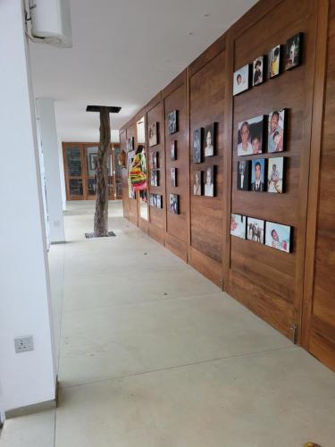 a hallway with a wall of pictures on the wall at Arachchi Heritage in Anuradhapura