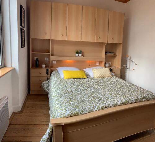 a bedroom with a large bed with yellow pillows at L appartement cosy in Le Garric