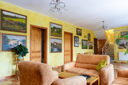 a living room with two chairs and a couch at Hotel Zéta in Lenti