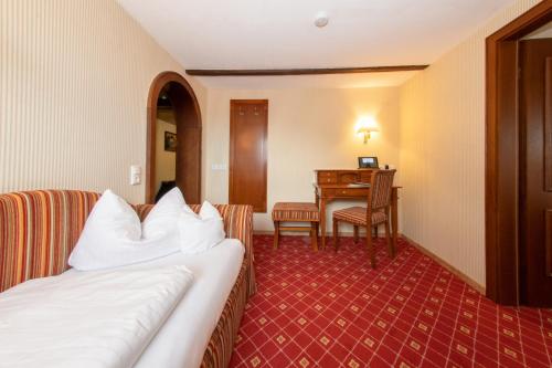a hotel room with a bed and a desk at Hotel Gasthof Post in Nesselwang