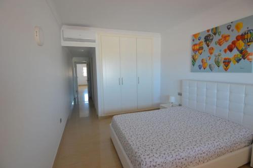 ein Schlafzimmer mit einem Bett und einem Gemälde an der Wand in der Unterkunft DeLuxe Apt. 110qm+Terrasse 60qm Pool WIFI Golf Yachthafen in San Miguel de Abona