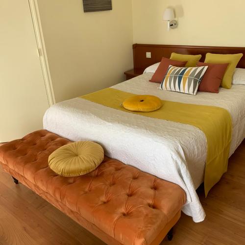 a bedroom with a large bed and a brown couch at Auberge Du Cheval Blanc in Beaumont-Pied-de-Boeuf