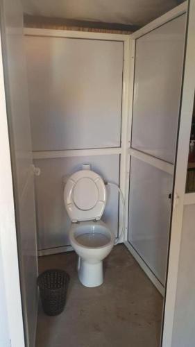 a small bathroom with a toilet in a stall at Desert Camp Erg Chebbi in Merzouga