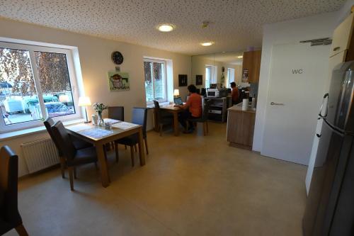 a kitchen with a table and chairs and a person sitting at a table at Motel55 - nettes Hotel mit Self Check-In in Villach, Warmbad in Villach