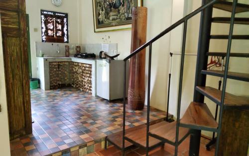 a kitchen with a staircase and a kitchen with a counter at Mi Casa - The gem of Ijen in Banyuwangi
