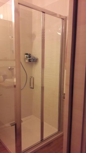 a shower with a glass door in a bathroom at LILIOM Apartment with FREE PARKING space in Budapest