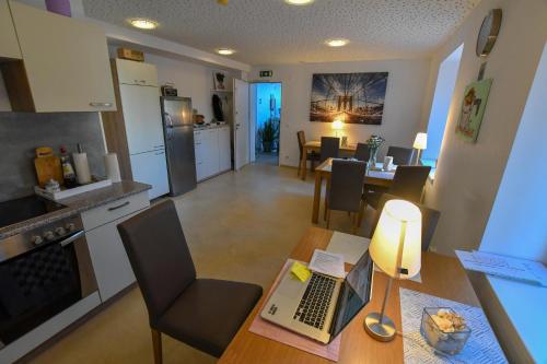 a kitchen and living room with a table with a laptop on it at Motel55 - nettes Hotel mit Self Check-In in Villach, Warmbad in Villach