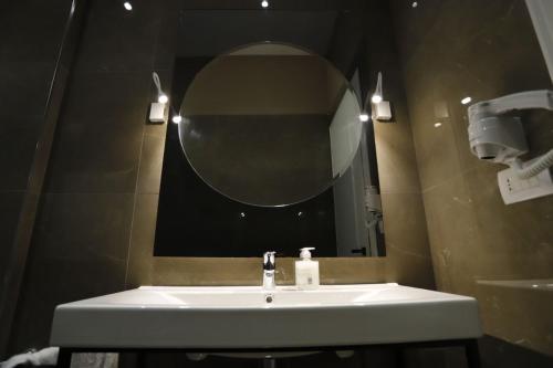a bathroom with a sink and a mirror at Admiral Hotel in Elbasan