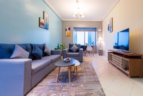 a living room with a couch and a tv at Trinity Holiday Homes - Sheikh Zayed Road Near to Financial Center Metro Station in Dubai