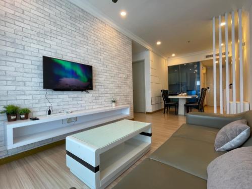 a living room with a tv on a brick wall at The Wave Suites Melaka in Melaka