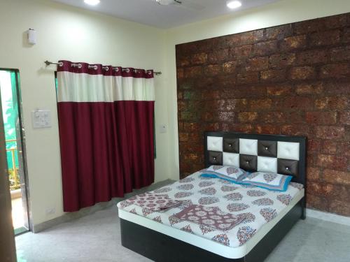 um quarto com uma cama e uma parede de tijolos em Aamantran Residency em Dapoli