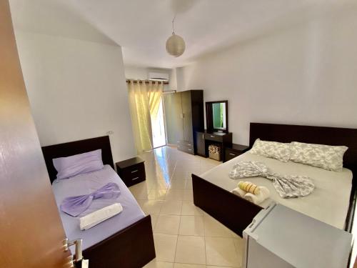 a bedroom with two beds and a tv in it at Vila Llaka in Himare